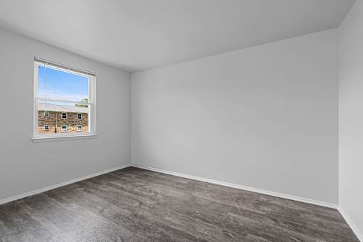 A room with a window showing a view of a building outside.