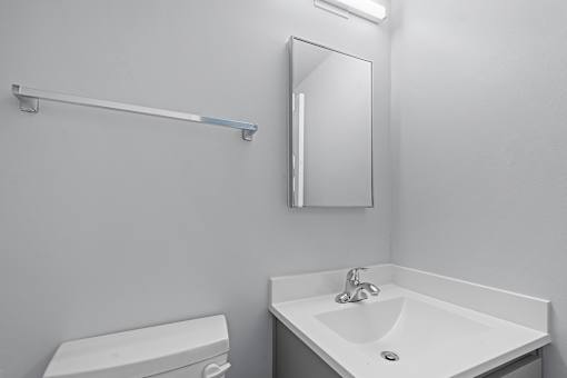 A white toilet sits next to a white sink in a bathroom.
