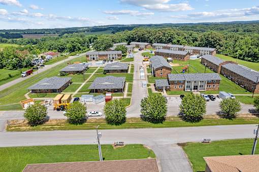 A large building complex with a parking lot in front.