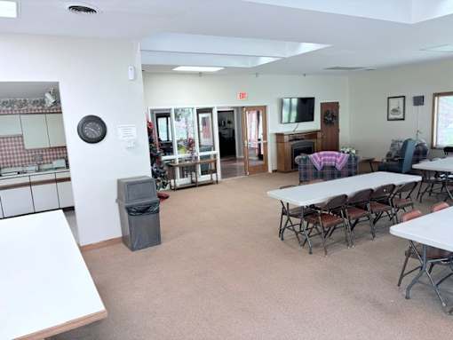 A room with tables and chairs and a clock on the wall.