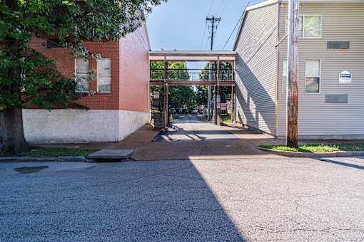 A parking lot with a building and a tree.