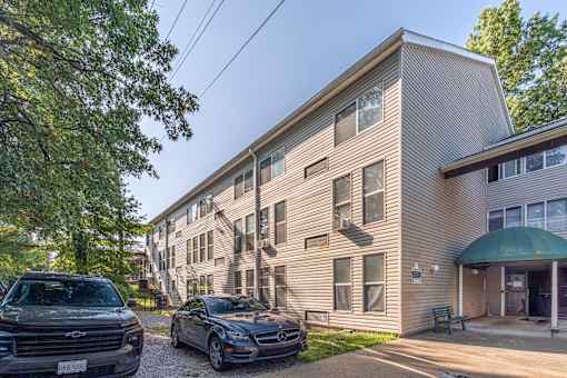 A Ford truck is parked in front of a two-story apartment building.