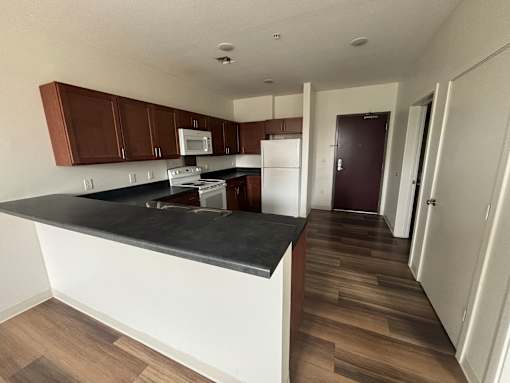 A kitchen with brown cabinets and a black countertop.