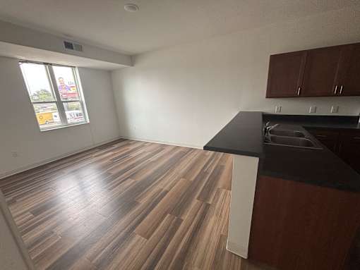 A kitchen with wooden floors and a black countertop.