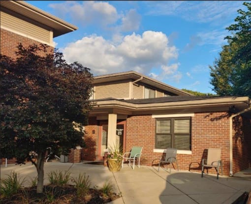 a brick house with a patio and chairs