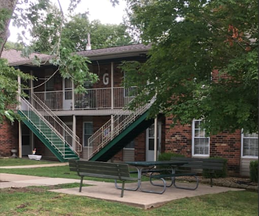 an exterior view of a building with a picnic table in front