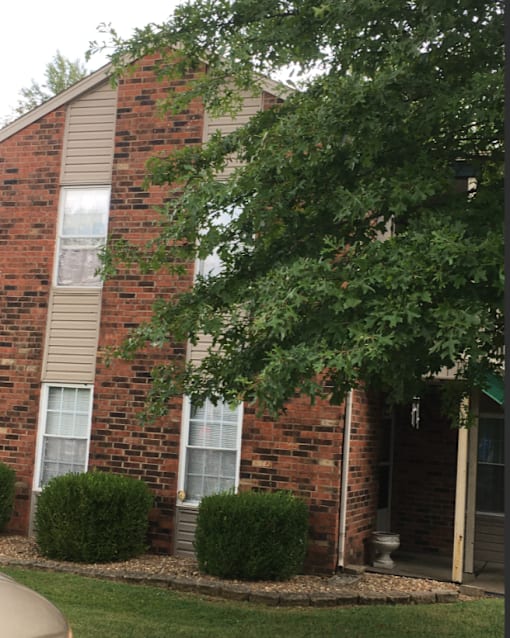 a brick house with a tree in front of it
