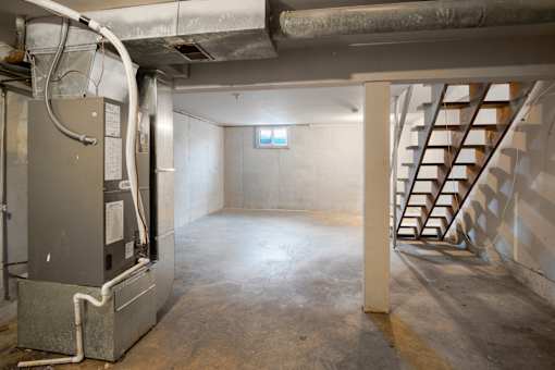 A room with a furnace and a staircase.