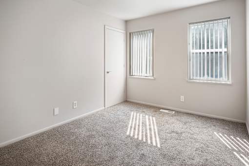 A room with a carpet and a door.