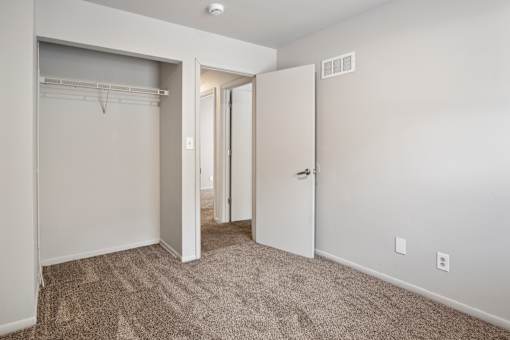 A room with a carpeted floor and a white door.