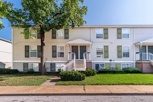 A two-story apartment building with a tree in front.