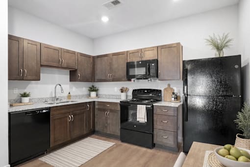 A kitchen with black appliances and wooden cabinets.