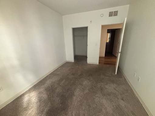 A room with a grey carpet and white walls.
