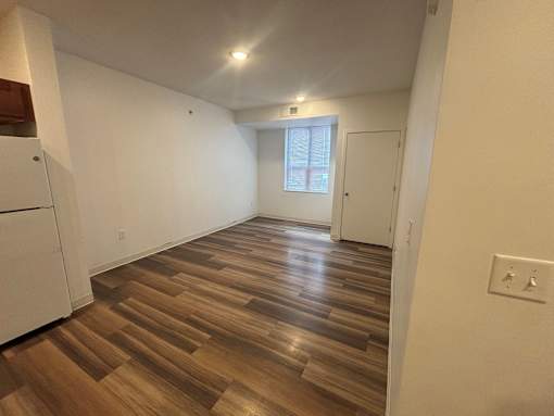 A room with wooden flooring and white walls.
