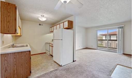 A kitchen with a white fridge and a ceiling fan.