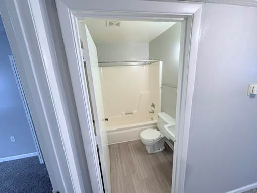 A white bathroom with a toilet and a bathtub.