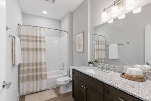 A bathroom with a toilet, sink, and shower.