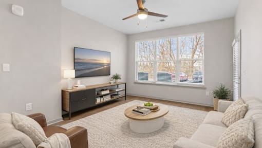 A living room with a brown couch, a coffee table, and a painting on the wall.