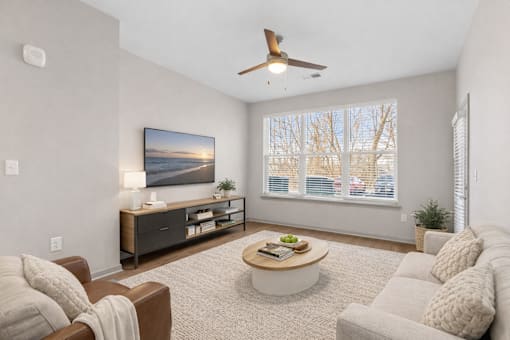 A living room with a brown couch, a coffee table, and a painting on the wall.