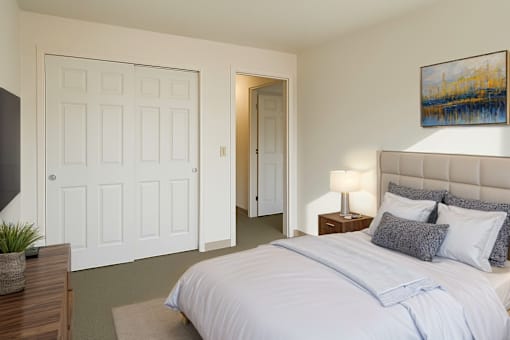 A bedroom with a large bed and a painting on the wall.