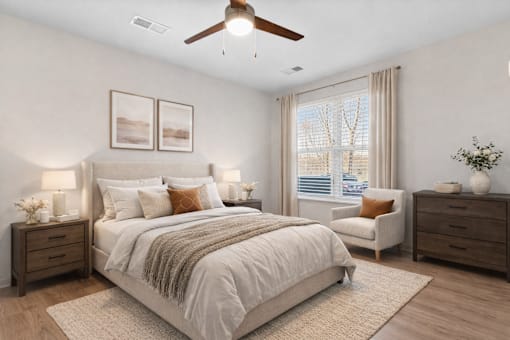A bedroom with a large bed, a chair, and a ceiling fan.