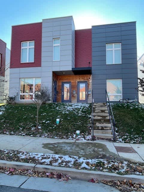 A modern two-story house with a red and grey exterior.