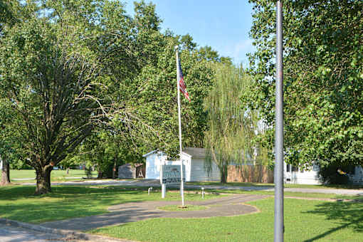 a flag pole with an flag in a park