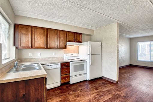 A kitchen with white appliances and wooden cabinets.