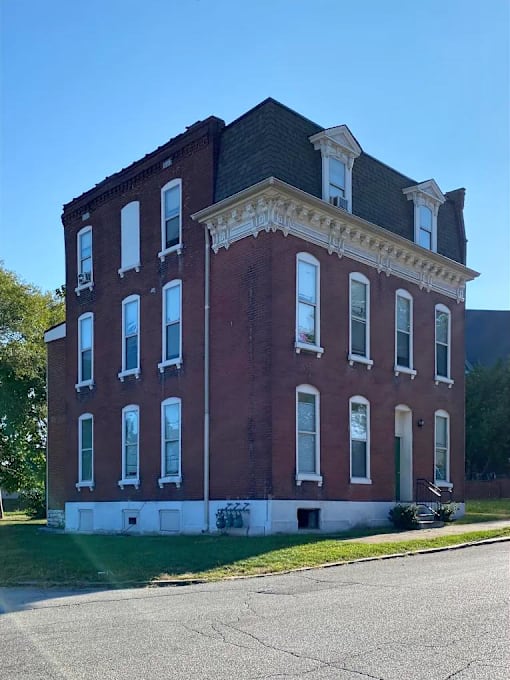 A red brick building with white trim and a black roof.