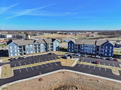 A large parking lot is in front of a large building.