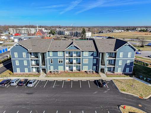 A large blue building with a parking lot in front.