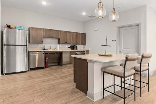 A kitchen with a white counter and brown chairs.