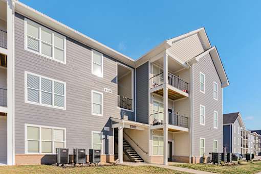 A modern apartment building with a clear blue sky in the background.