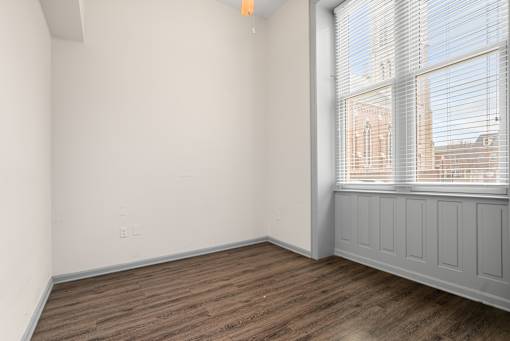 Empty room with wooden floor and white walls.
