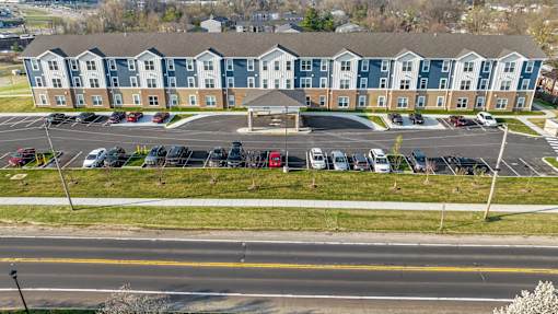 a parking lot with cars in front of an apartment building