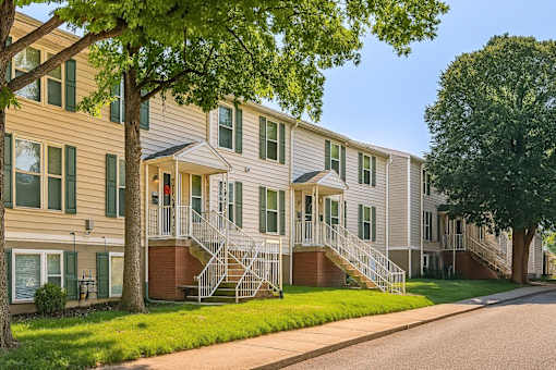 Apartment building with green trees in front.