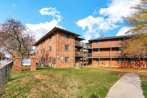a brick apartment building with a sidewalk in front of it