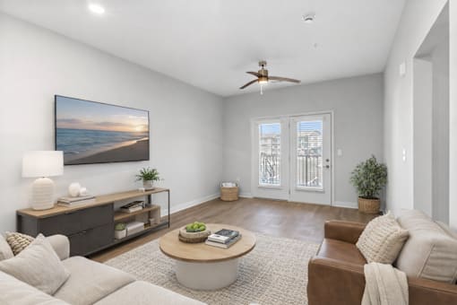 A living room with a large painting of a beach scene on the wall.