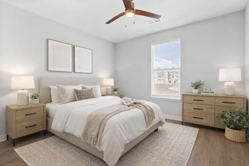 A bedroom with a bed, nightstands, and a ceiling fan.