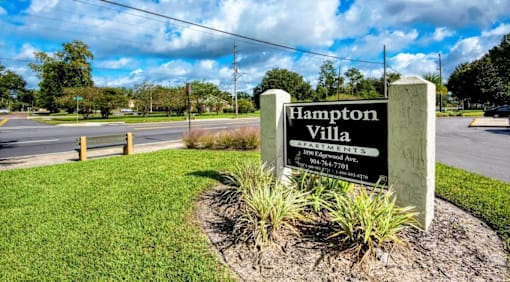 Hampton Villa Apartments sign in front of a grassy area.