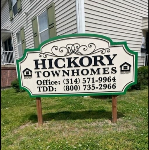 A sign for Hickory Townhomes with contact information.