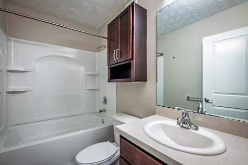 A white toilet sits next to a sink in a bathroom.