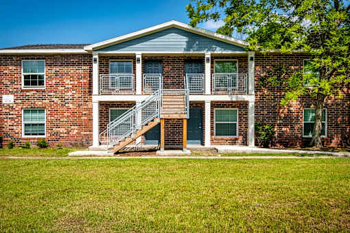 A brick building with a blue roof and a staircase leading to the second floor.