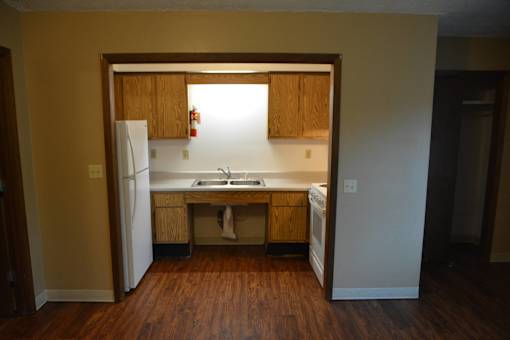 an empty kitchen with a sink and a refrigerator