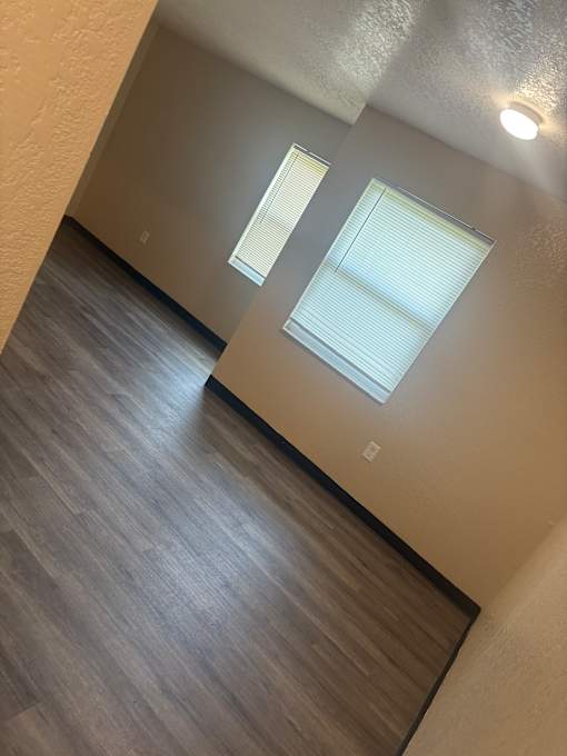 A room with a wooden floor and two skylights.