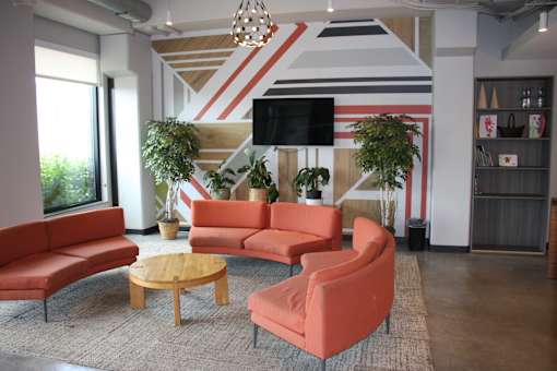 a living room with orange couches and chairs and a television