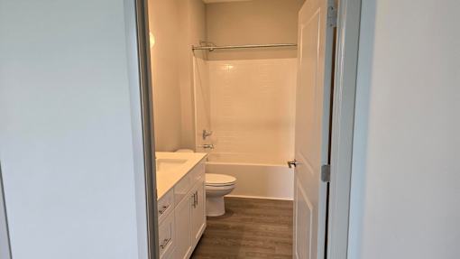 A white bathroom with a toilet, sink, and bathtub.