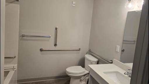 A bathroom with a toilet, sink, and shower.