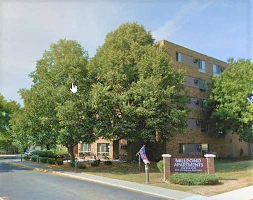 a building with a sign and trees in front of it