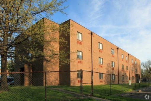 a brick building with a fence in front of it